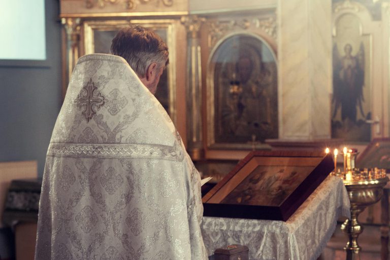 Father Standing in Front of Alter