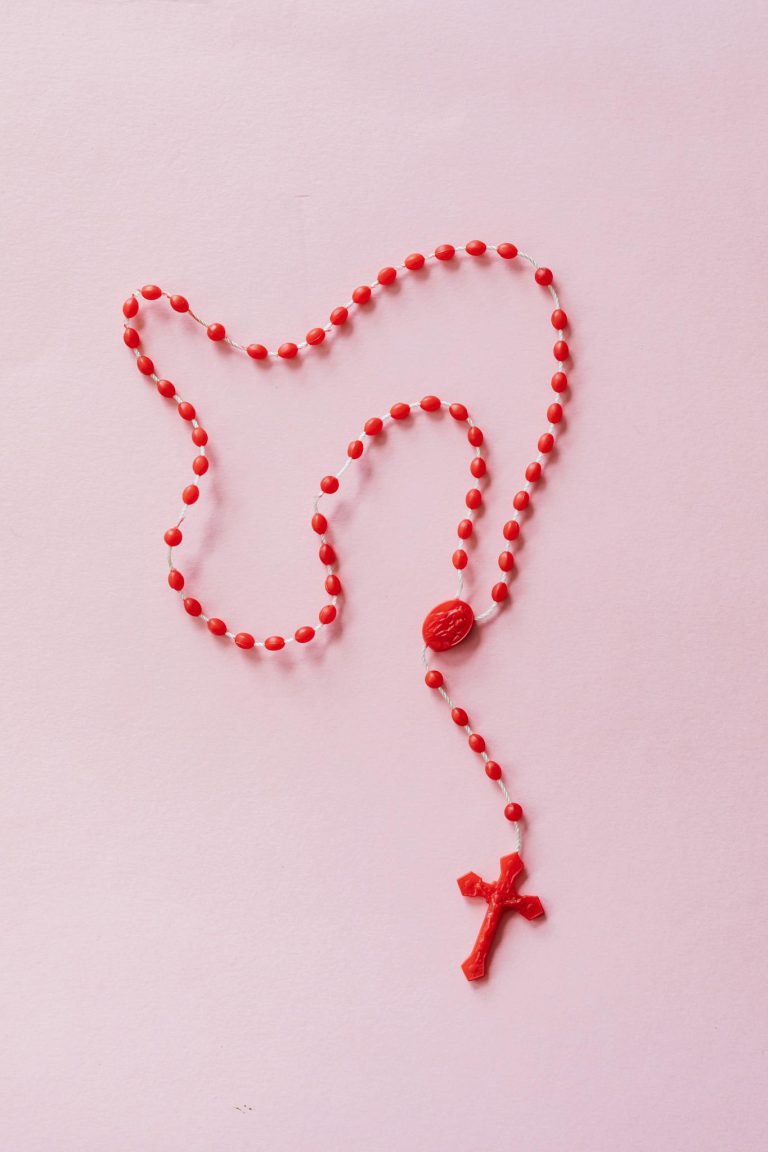 Red Rosary on Pink Surface